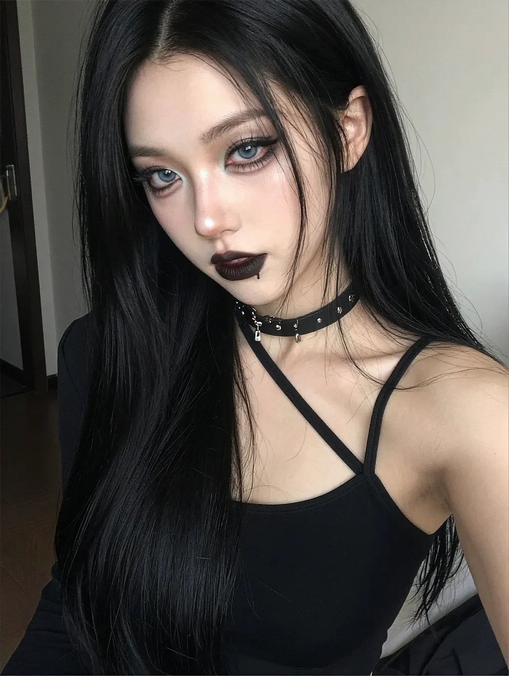 Fictional AI character with black hair, dark lipstick and a choker in low light