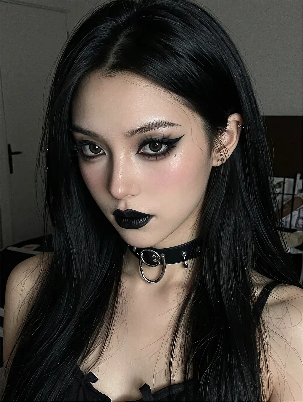 Fictional AI character with heavy goth eye makeup, black lipstick and a choker
